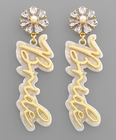 A pair of dangling earrings reading "bride" in gold.