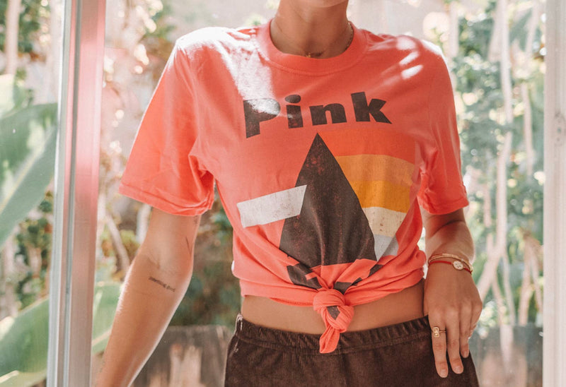A bright coral graphic t-shirt with the Pink Floyd logo in the center. 