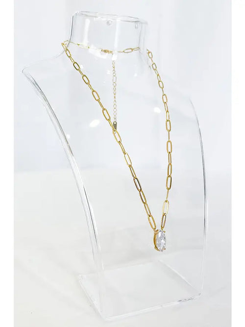 A long gold chain necklace with a marquise pendant. 