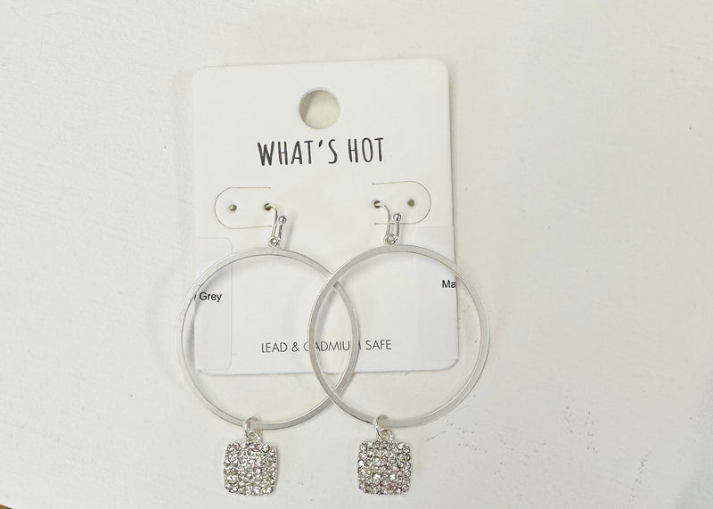 A pair of silver dangling hoops with a circular shape and rhinestone pendants at the bottom. 