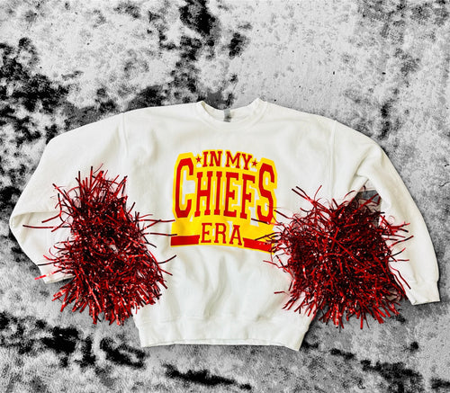 A white crewneck with "In My Chiefs Era" across the front in a bright yellow and red font.
