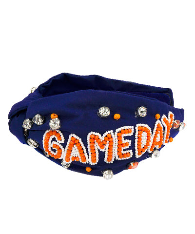 A navy wide headband with silver and orange jewels and "gameday" written in orange beading.