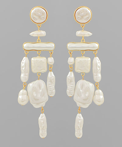 A pair dangling earrings that feature ivory pearls and gold detailing.