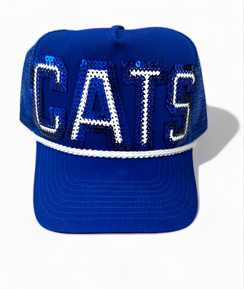 A royal blue baseball cap with "cats" written in blue and white sequins and features a rope detailing.