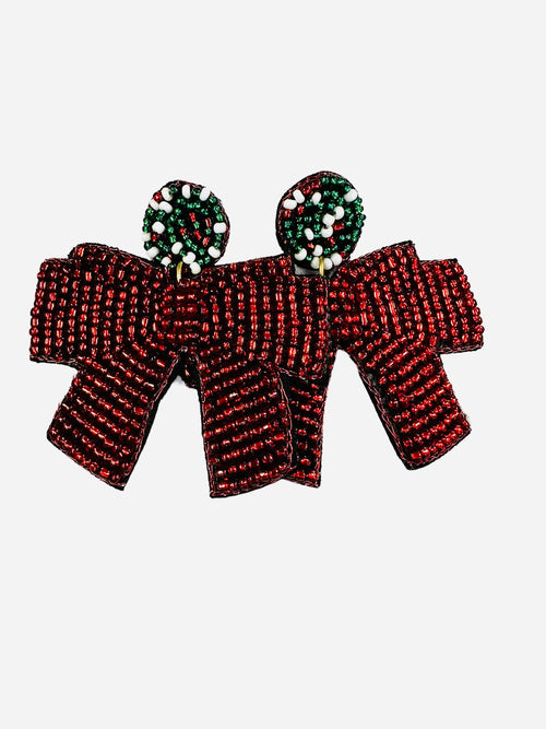 A large pair of beaded earrings in the shape of red bows.