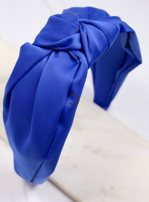A royal blue, wide headband with a knot detailing in the center.