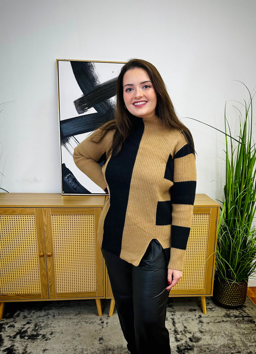 A beige and black color block, high-neck sweater with an asymmetrical print and v-slit on the bottom.