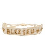 A white and gold strap bracelet that has "blessed" written in beads and features an adjustable strap.