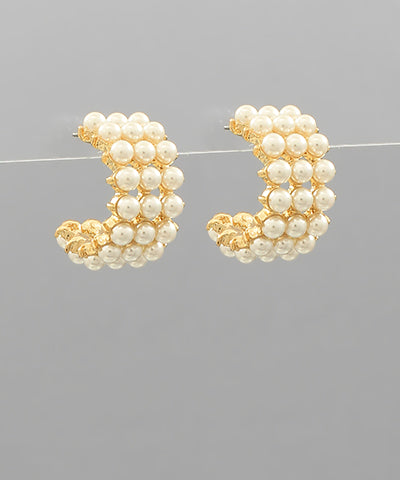 A pair of chunky gold hoops with pearls.