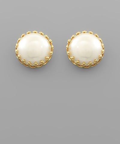 A pair of pearl stud earrings with gold outer detailing. 