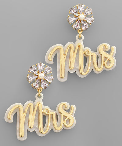 A pair of gold and diamond dangling earrings with "Mrs" written on each.