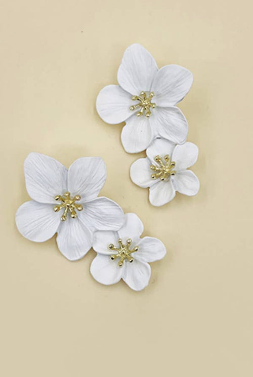 A pair of chunky earrings with 3D white flowers and a gold center.