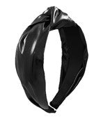 A black shiny fabric wide headband with a knot detail in the center. 
