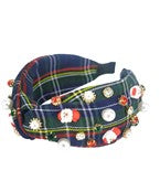 A navy and green plaid wide headband with christmas themed jewels.