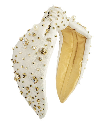 An ivory wide headband with gold jewels throughout. 