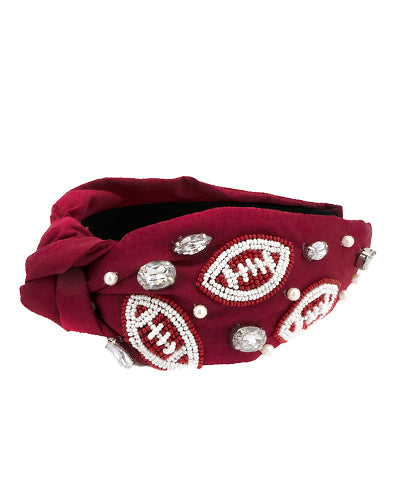 A maroon wide headband featuring chunky rhinestones and beads in the shape of footballs.