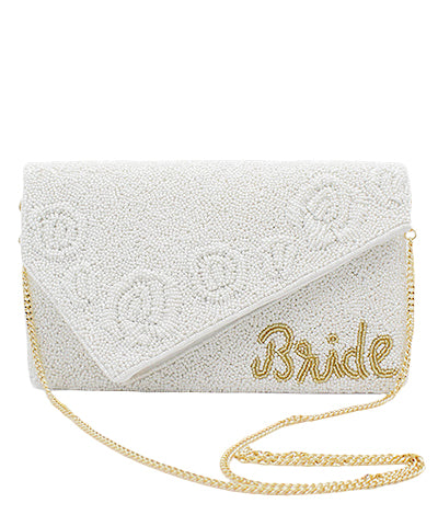 A white beaded clutch with "Bride" written in gold beading and has a gold chain strap.