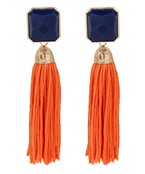 A pair of navy earrings with a hanging orange tassel and gold detailing. 