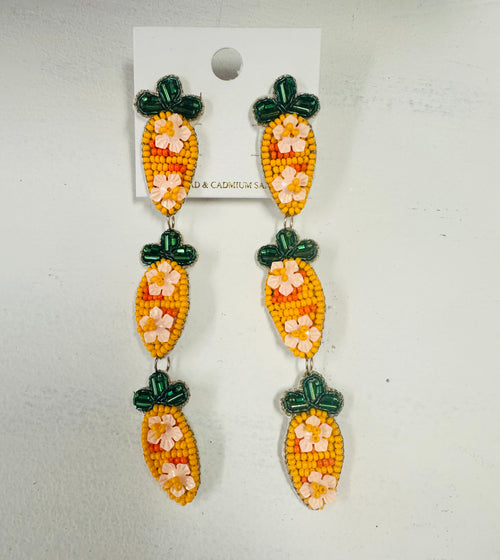 A large pair of beaded earrings in the shape of three carrots - one on top of the other.