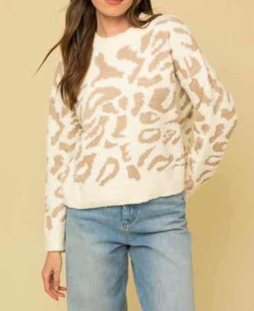 An ivory sweater with tan leopard print throughout.
