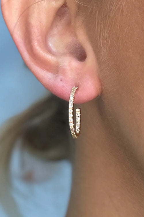 A pair of medium sized gold hoops with rhinestones throughout.