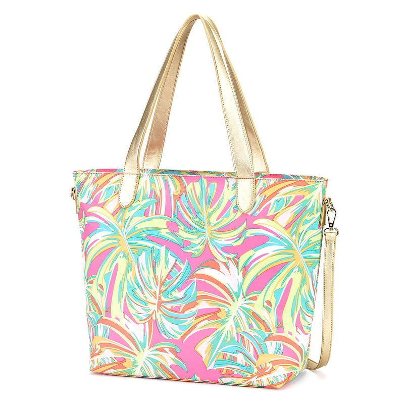 A beach tote with multicolored tropical leaf detailing and gold straps.