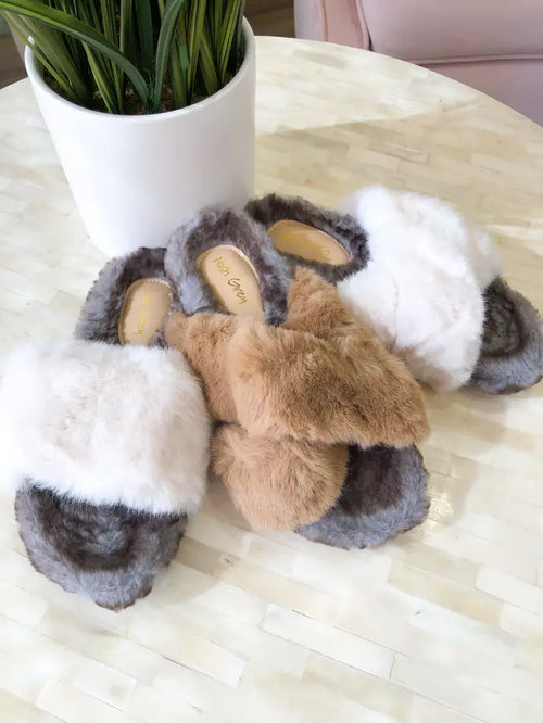 Multicolored neutral house slippers made out of faux fur.
