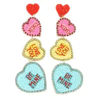 A pair of dangling earrings with 3 hearts stacked on top of each other in the style of colorful valentine's day candies. 