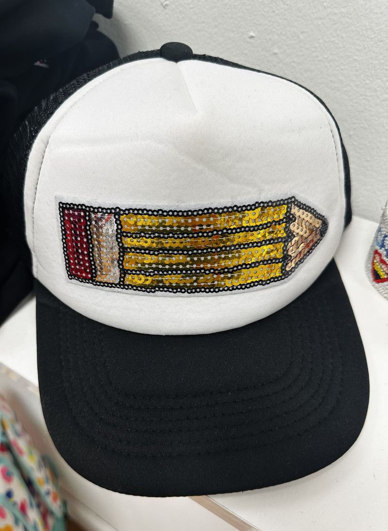 A white and black trucker hat with a sequin patch in the shape of a pencil.