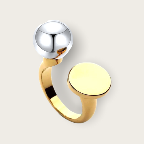 A gold ring with a silver ball on one side, then an opening and a gold circle on the other side.