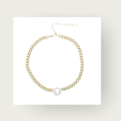A gold chain bracelet with a heart cutout pendant. 