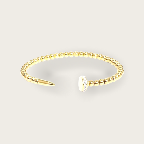 A gold beaded nail style bracelet with diamonds on the nail head.
