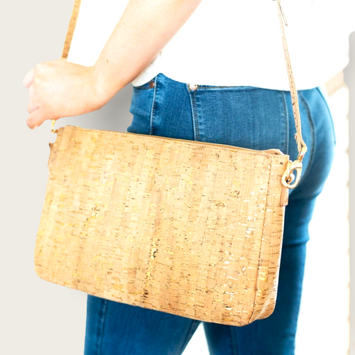 A crossbody purse made with a cork-like fabric and gold chain for the strap.