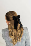 A black hair bow in a velvet fabric.