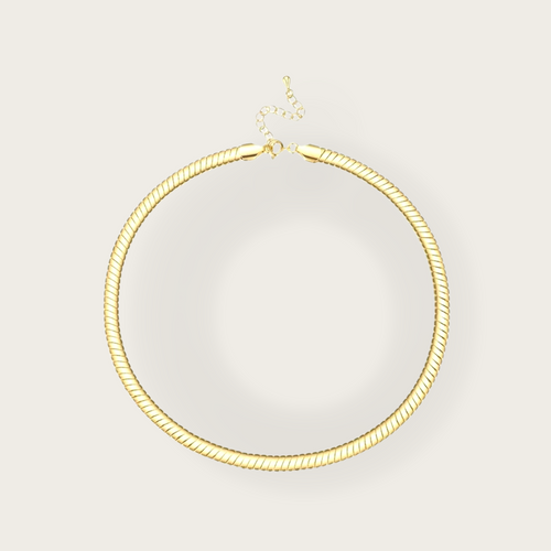 A gold short necklace with a striped texture. 