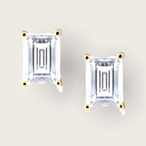 A pair of emerald cut diamond studs with gold detailing. 