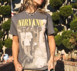 A grey graphic t-shirt with "nirvana" across the top in yellow followed by a photo of the band. 