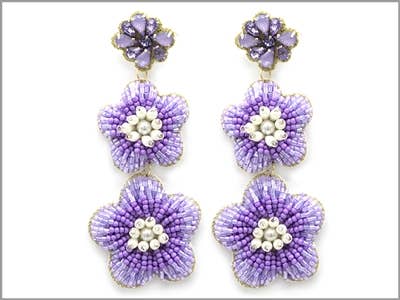 A pair of purple dangling earrings in the shape of three flowers and features beading throughout.