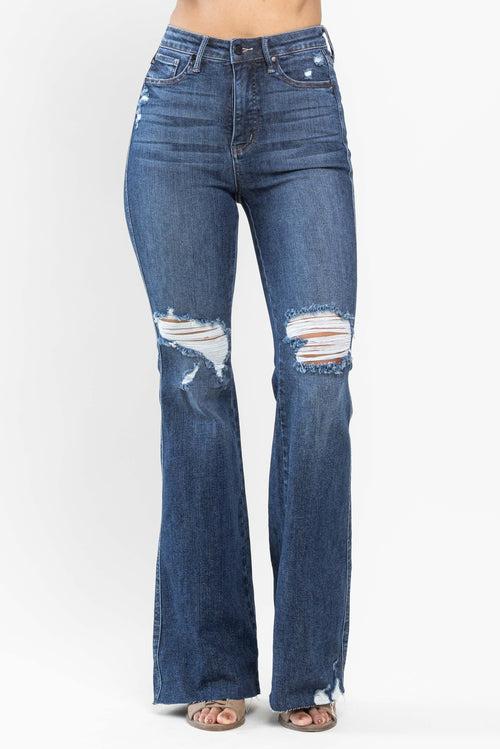A pair of dark wash, high-waisted jeans with distressed holes in the knees and a wide leg.