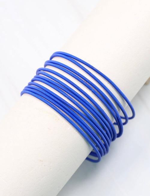 A set of skinny royal blue bracelets that stretch.
