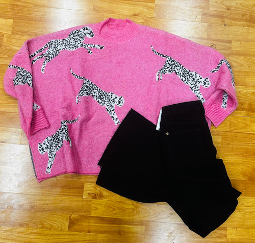 A bright pink sweater featuring black and white cheetahs and a high neck detail.