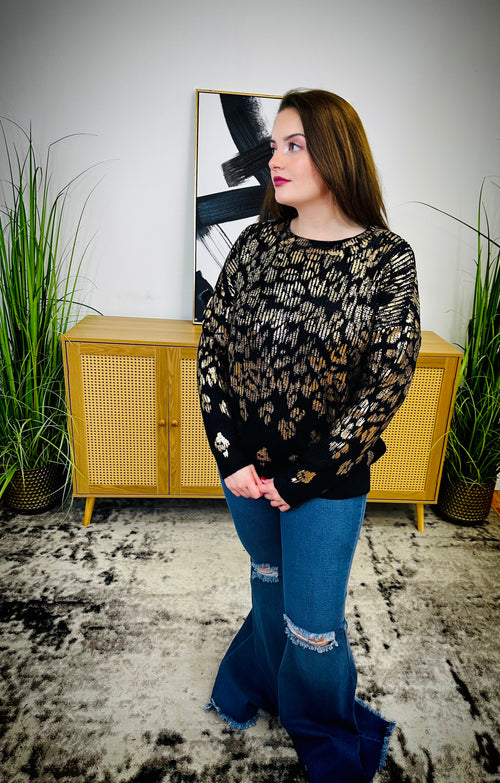  A black and silver metallic sweater with a leopard print and scoop neck.