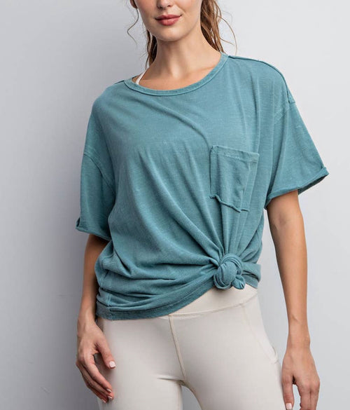 An oversized, washed out turquoise t-shirt featuring a pocket on the front.