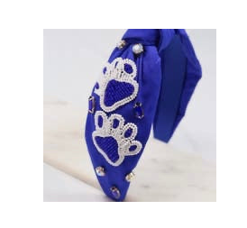 A royal blue wide headband with paw print patches on the sides. 