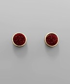 A pair of maroon and gold stud earrings. 
