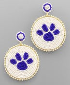 A pair of beaded dangling earrings in the shape of a white circle and blue paw prints in the center. 