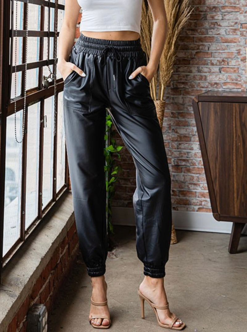 A pair of black leather joggers featuring a high waist, drawstring adjusting, and pockets.