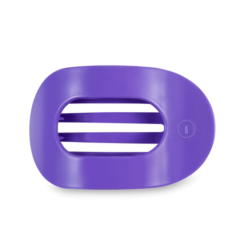 A flat round hair clip in the color electric purple. 