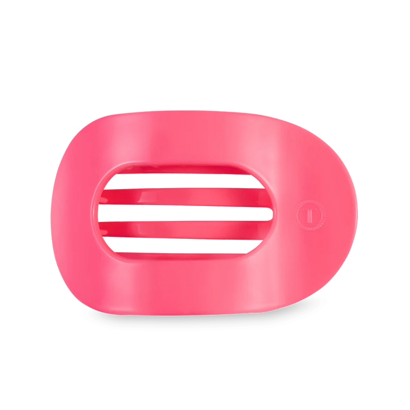 A flat round hair clip in the color hot pink. 