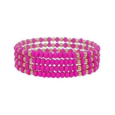 A set of 4 beaded bracelets in hot pink wood and gold.